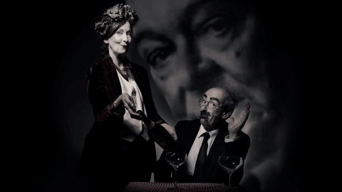 Dinner With Groucho by Frank McGuinness. A waitress is showing a bottle of wine to a seated gentleman. The gentleman is Groucho Marx. In the background, there is a large image of T.S. Eliot