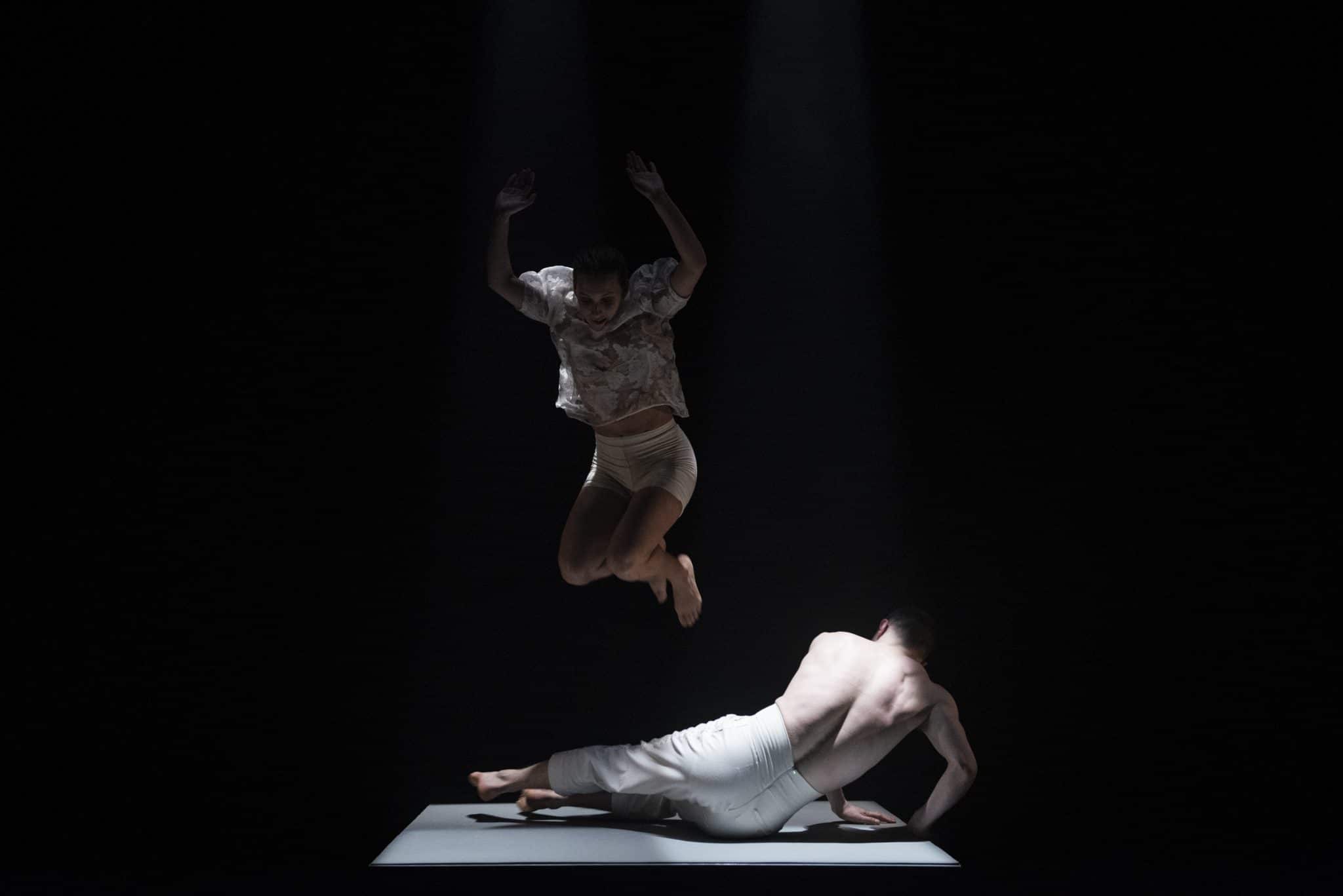 One dance is jumping mid air above a second dancer who is lying on the floor, attempting to get up. From Brink, 2020, commissioned by Maiden Voyage Dance Company. Photo Credit Luca Truffarelli