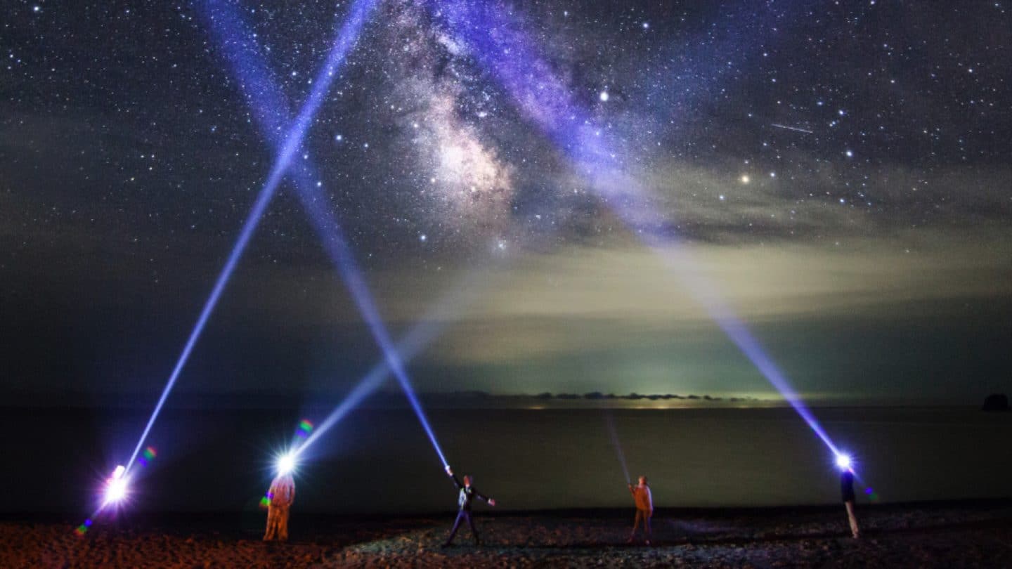 A picture showing search lights strobing the sky.